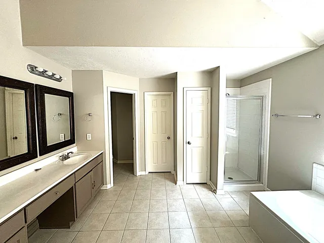 a spacious bathroom with a mirror and a bathtub