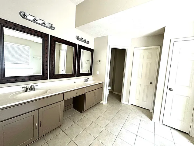 a large bathroom with a double vanity sink mirror and bathtub