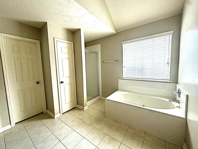 a spacious bathroom with a bathtub and a shower