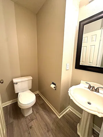 a bathroom with a toilet a sink and mirror