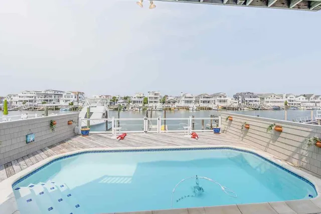 an aerial view of ocean and residential houses with outdoor space