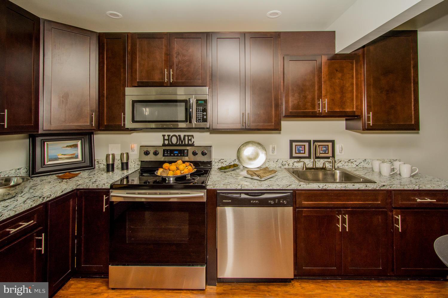 3504 Offutt Road Randallstown, MD 21133 - Photo 14 of 30 a kitchen with granite countertop wooden cabinets and a stove top oven