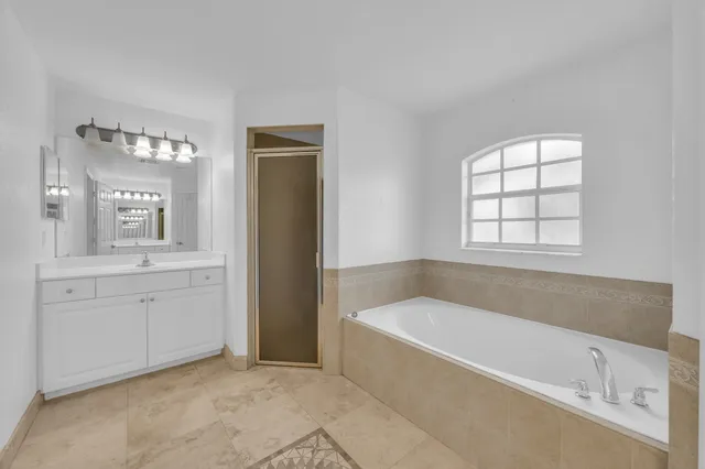 a bathroom with a tub a sink and a window