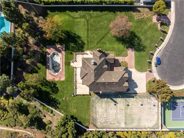 an aerial view of a house with a yard and large trees