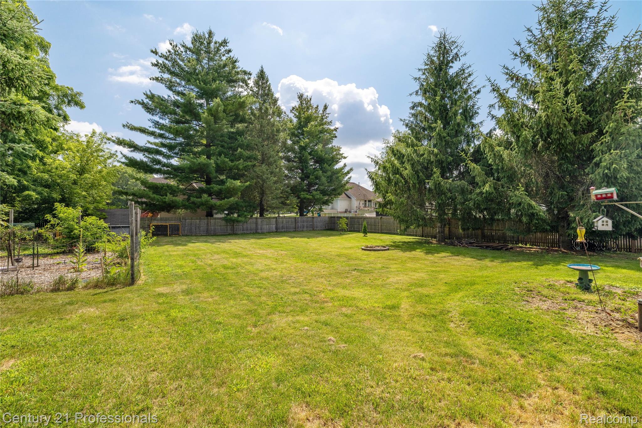 15037 Hogan Road Linden, MI 48451 - Photo 31 of 38 Expansive grassy yard area featuring mature trees and a wood privacy fence