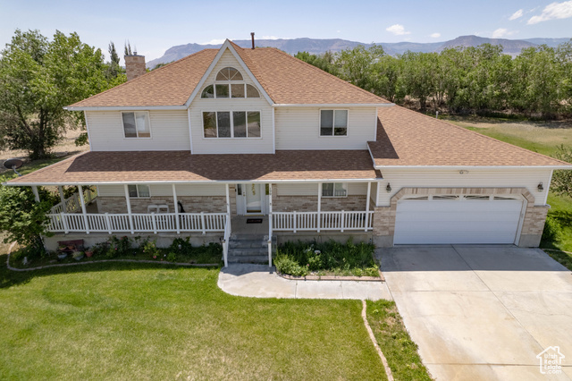 190 600 North Ferron, UT 84523 - Photo 70 of 85 View of front facade with a chimney, concrete driveway, covered porch, an attached garage, and roof with shingles