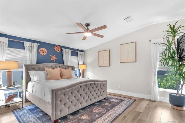 a bedroom with a large bed and a potted plant