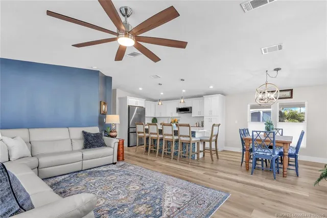 a living room with furniture kitchen view and a wooden floor