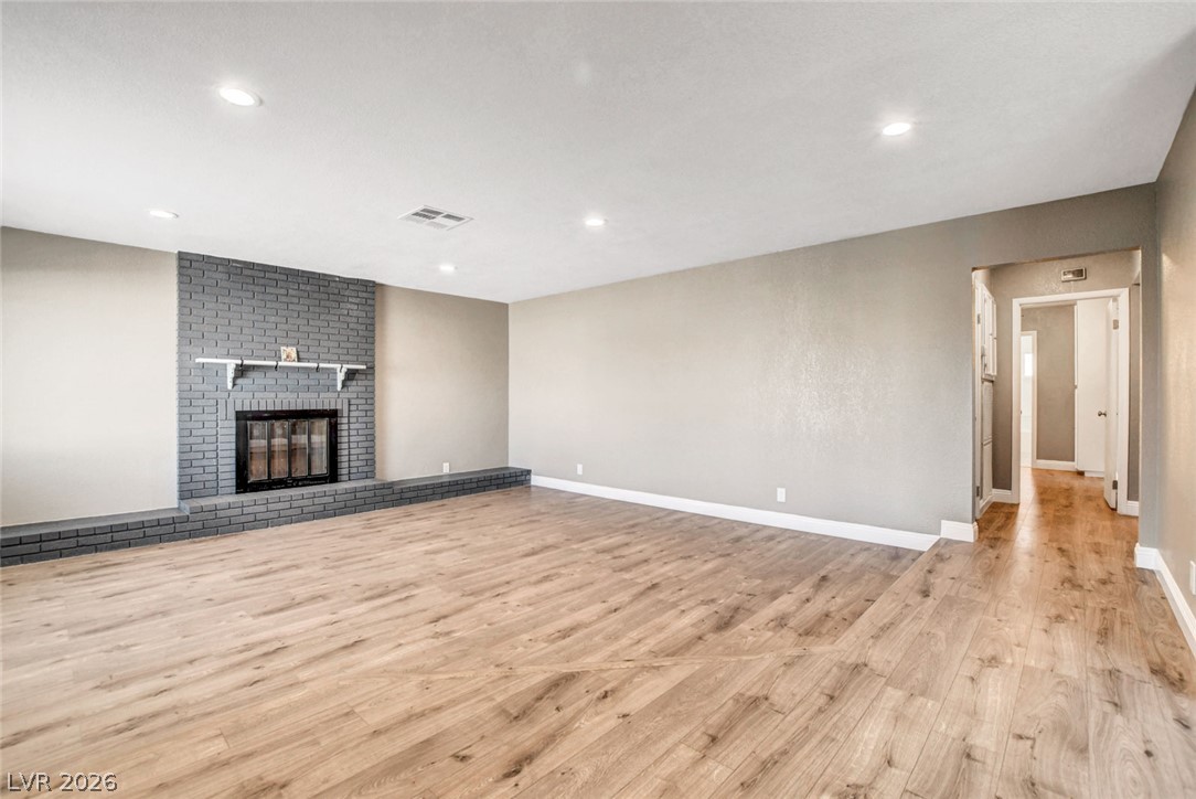 4367 South Mojave Road Las Vegas, NV 89121 - Photo 5 of 53 A well-lit living area features a charming brick fireplace and sleek wood flooring.