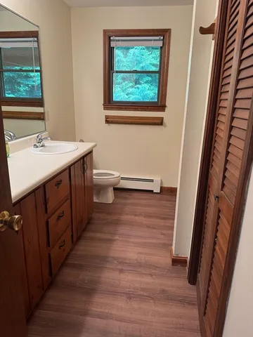 a bathroom with a sink a toilet a mirror and a window