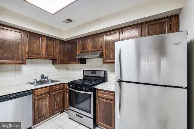 a kitchen with stainless steel appliances granite countertop a refrigerator sink and cabinets