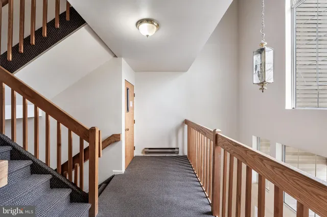 a view of a hallway with wooden floor and stairs