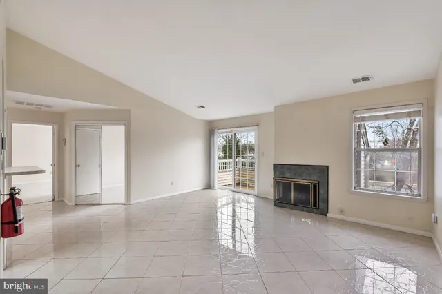 an empty room with windows and fireplace