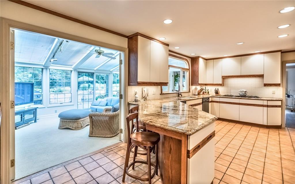 2390 Fairhill Road Sewickley, PA 15143 - Photo 9 of 25 Peninsula Island Kitchen, Sleek Granite Countertops, Bar Stool Ledge, Gas Cooking, Tile Backsplash & Abundant Custom Cabinetry with Under Cabinet Lighting