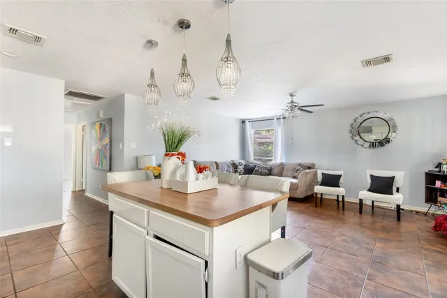 a living room with kitchen island furniture and a chandelier