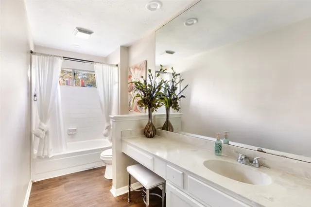 a bathroom with a granite countertop sink a mirror and a shower