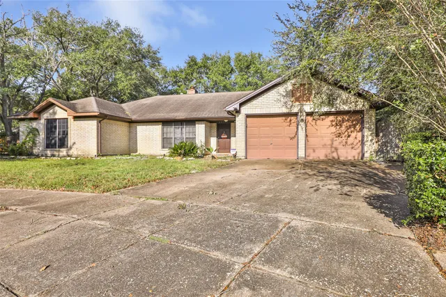 a front view of a house with a garden and trees