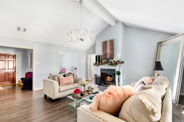 a living room with furniture a fireplace and a chandelier