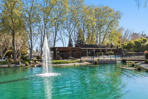 a view of backyard with swimming pool and seating space