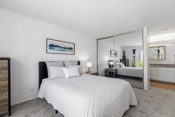 a bedroom with a bed and a large mirror