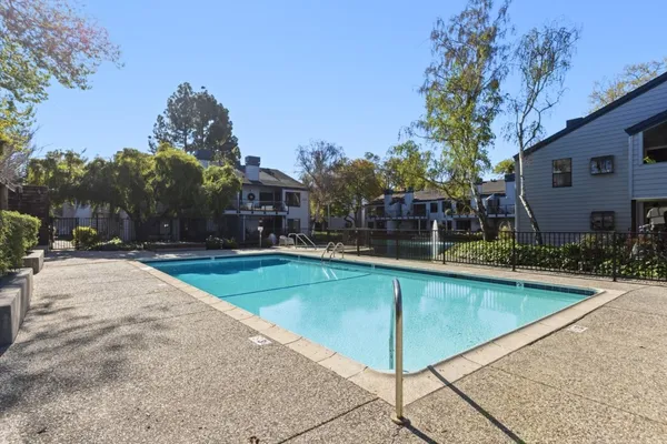 a view of swimming pool with outdoor seating and house in the background