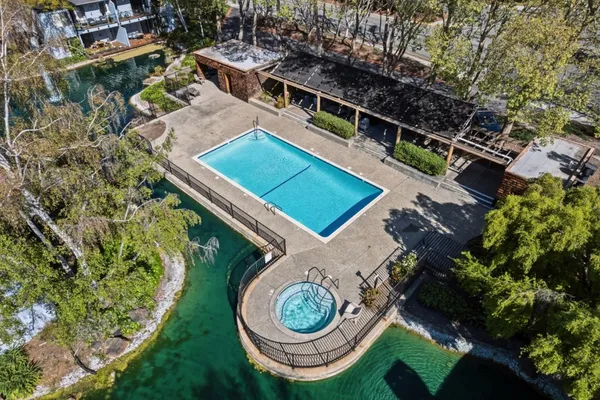 an aerial view of a house roof with outdoor space and trees all around