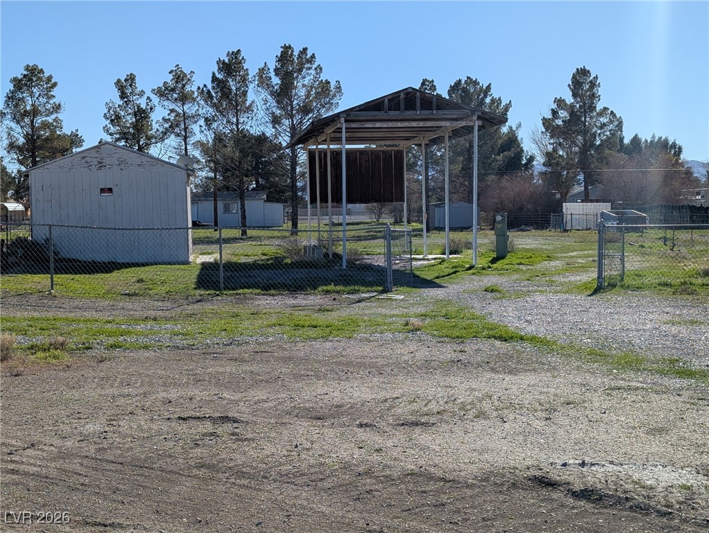 Shed and carport. Yard is partly fenced with circular drive.