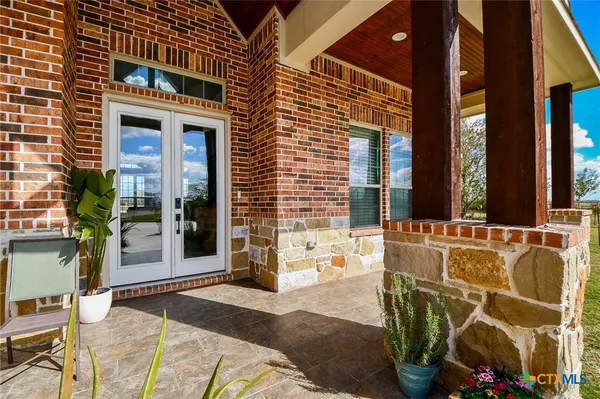 a view of a balcony with chairs and a potted plant
