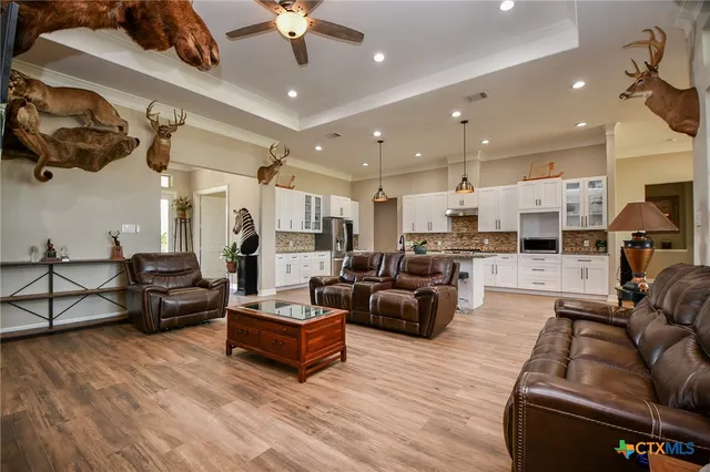 a living room with furniture kitchen view and a chandelier