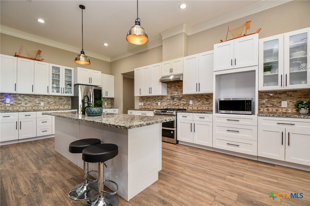 1093 Sunderman Road Alleyton, TX 78935 - Photo 23 of 48 a kitchen with a refrigerator a stove cabinets and wooden floor