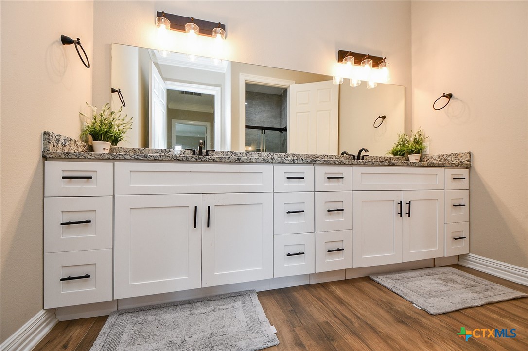 1093 Sunderman Road Alleyton, TX 78935 - Photo 34 of 48 a spacious bathroom with a granite countertop sink and a mirror