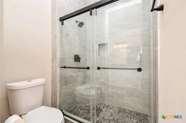 a white toilet sitting next to a bathroom shower