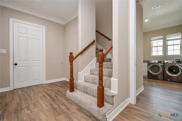 a view of a hallway with wooden floor and staircase