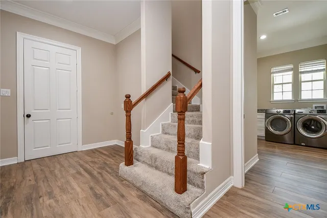 a view of a hallway with wooden floor and staircase