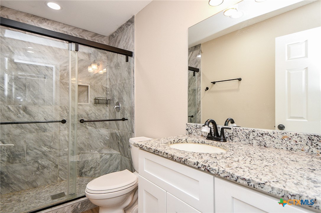 1093 Sunderman Road Alleyton, TX 78935 - Photo 40 of 48 a bathroom with a granite countertop sink toilet and shower