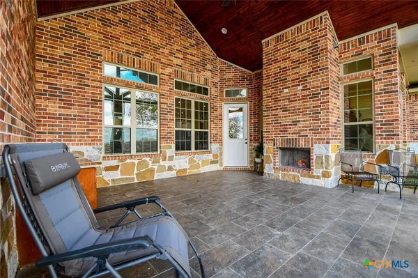 a view of a patio with table and chairs with wooden floor and fence