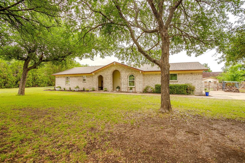 408 Jeri Ridge Road Willow Park, TX 76087 - Photo 2 of 38 Light-colored brick exterior featuring an arched entryway and established trees