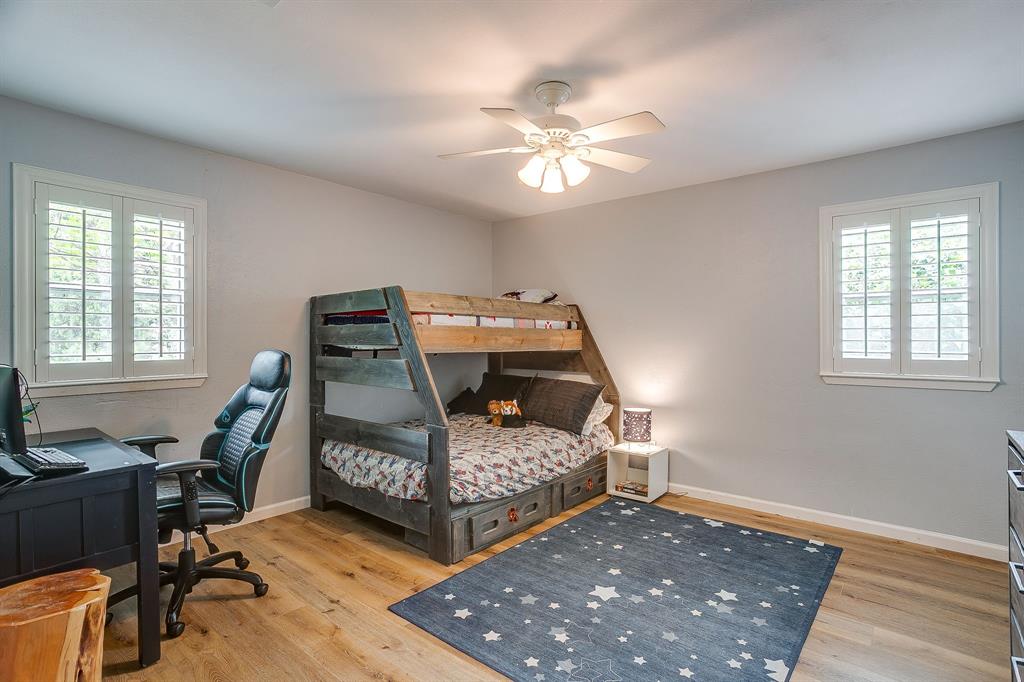 408 Jeri Ridge Road Willow Park, TX 76087 - Photo 23 of 38 Room featuring wood-finish flooring, light gray walls, and two windows with white plantation shutters