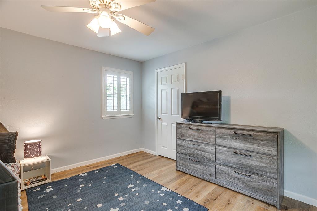 408 Jeri Ridge Road Willow Park, TX 76087 - Photo 24 of 38 Neutral-toned room featuring wood-finish flooring, a ceiling fan with light fixture, and a window with white plantation shutters
