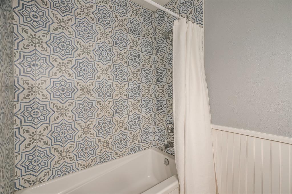 408 Jeri Ridge Road Willow Park, TX 76087 - Photo 26 of 38 Bathtub with a patterned tile surround, featuring blue and tan geometric designs