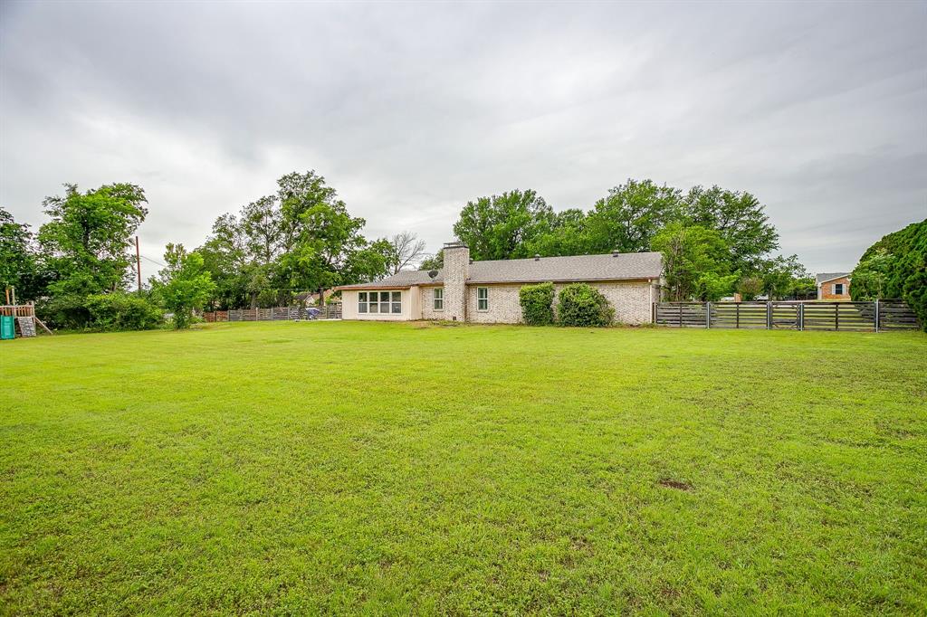 408 Jeri Ridge Road Willow Park, TX 76087 - Photo 35 of 38 Expansive lawn space featuring a brick exterior home, rear patio access, mature perimeter trees, and a dark-toned fence