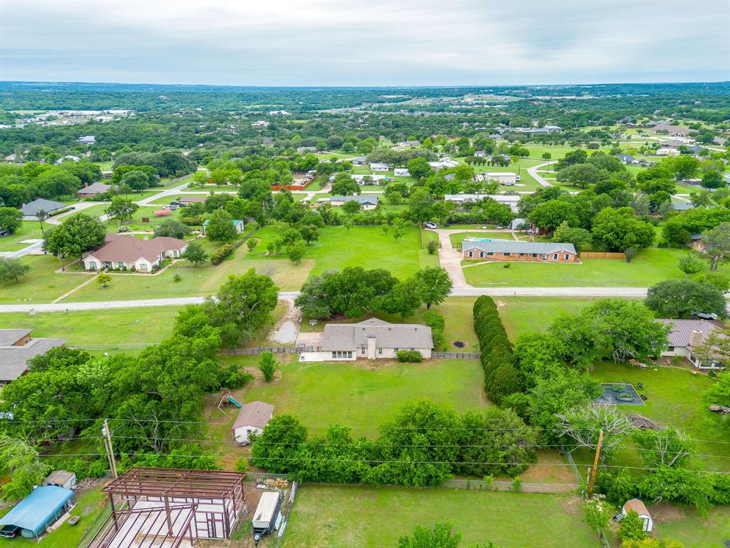 408 Jeri Ridge Road Willow Park, TX 76087 - Photo 38 of 38 Expansive green landscape with numerous mature trees, a single-story residence, and a separate outbuilding