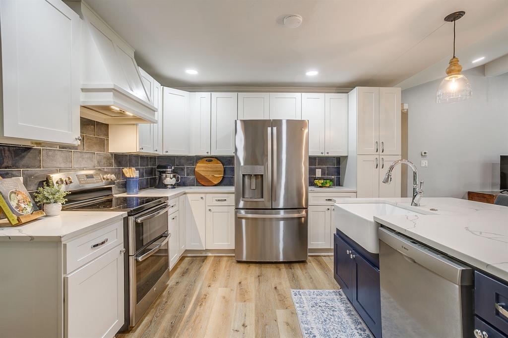 408 Jeri Ridge Road Willow Park, TX 76087 - Photo 10 of 38 Modern kitchen featuring white shaker-style cabinetry, wood-finish flooring, stainless steel appliances, a farmhouse sink with a gooseneck faucet, and light-toned countertops