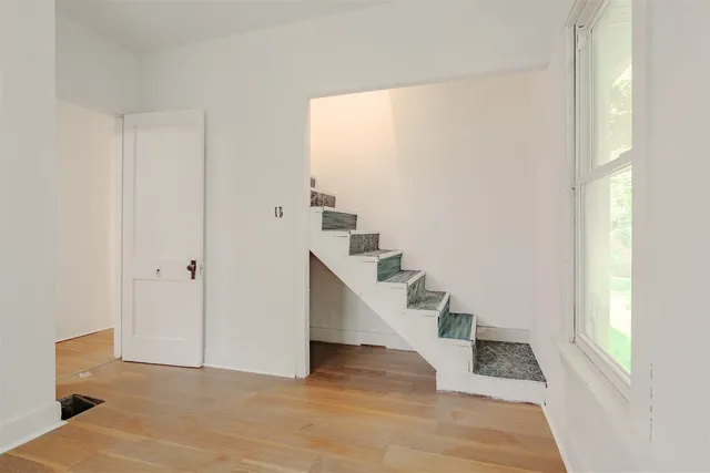 a view of an entryway with wooden floor and staircase