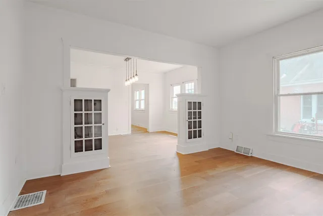 an empty room with windows and cabinet