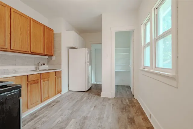 a view of a kitchen with wooden floor and electronic appliances