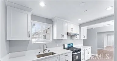 a kitchen with stainless steel appliances a sink stove and cabinets