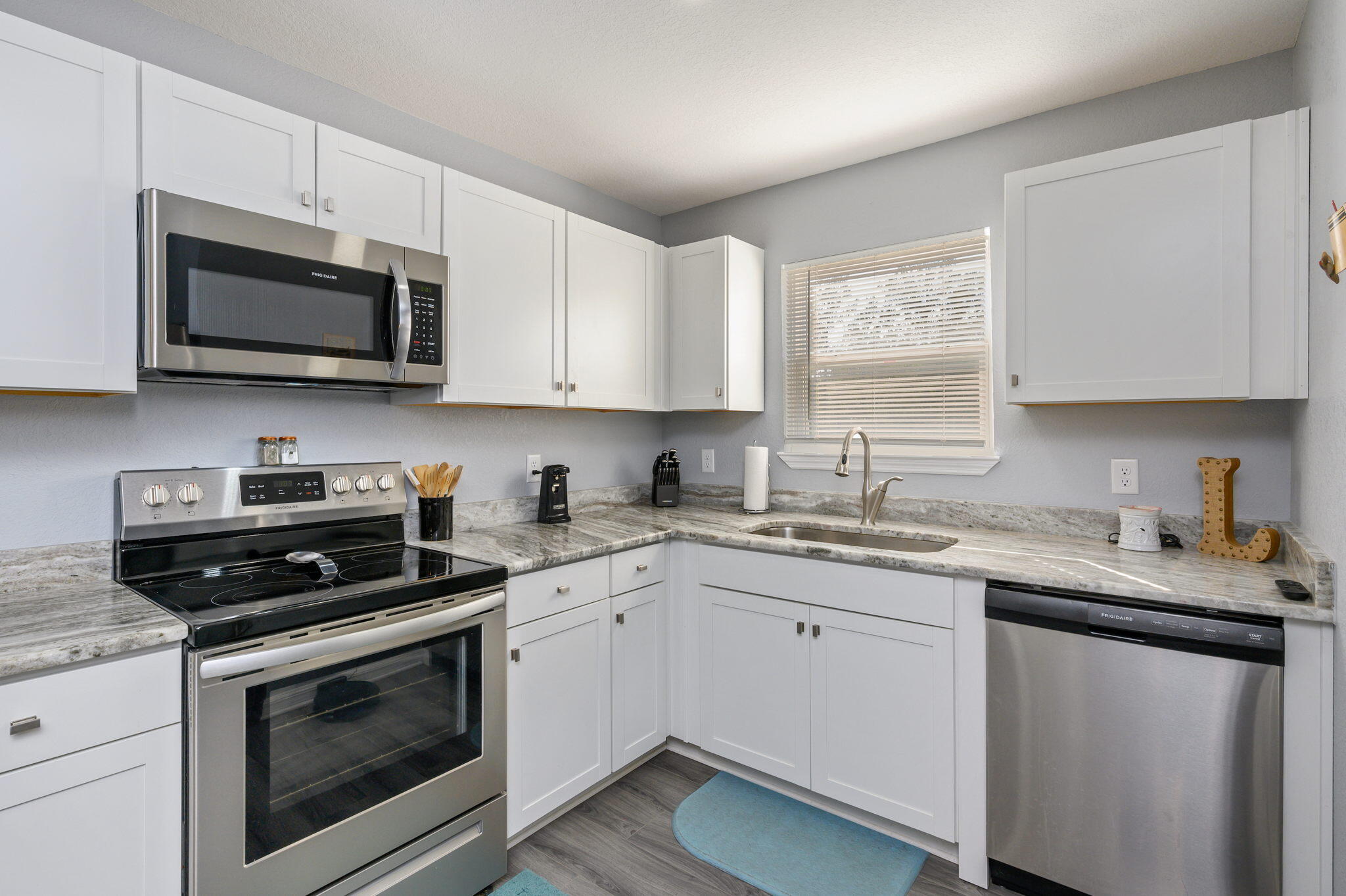 149 Delaware Road DeFuniak Springs, FL 32433 - Photo 11 of 36 a kitchen with stainless steel appliances granite countertop grey cabinets a sink and a stove