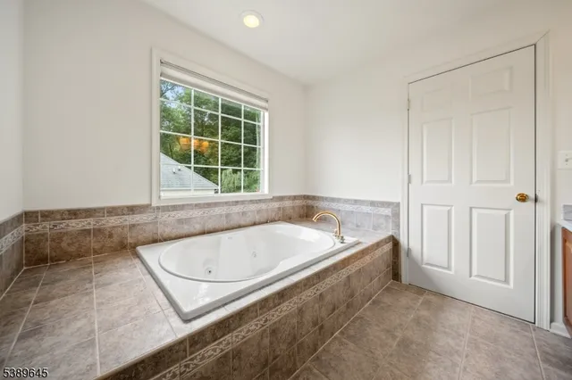a bathroom with a tub a window and a shower