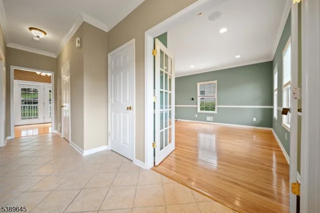 a view of a hallway with wooden floor and a bathroom